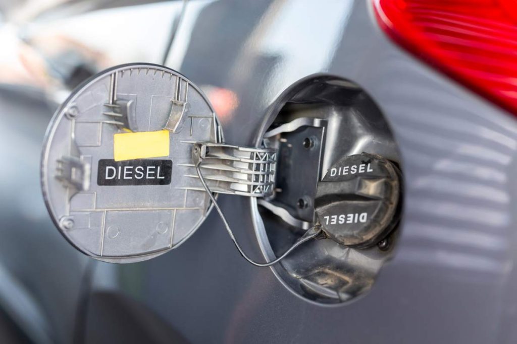 Close up of fuel tank door of the car; car refueling at a petrol station; car tank refilling at a gas station