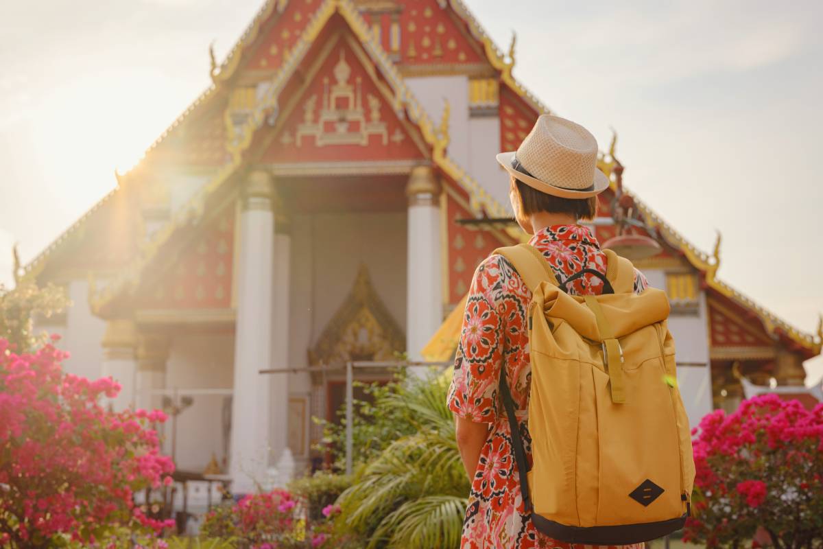 Travel to Ayutthaya, Thailand. Young female tourist explores modern Buddhist temples, surrounded by vibrant architecture and cultural symbols, capturing essence of spirituality and Thai heritage.